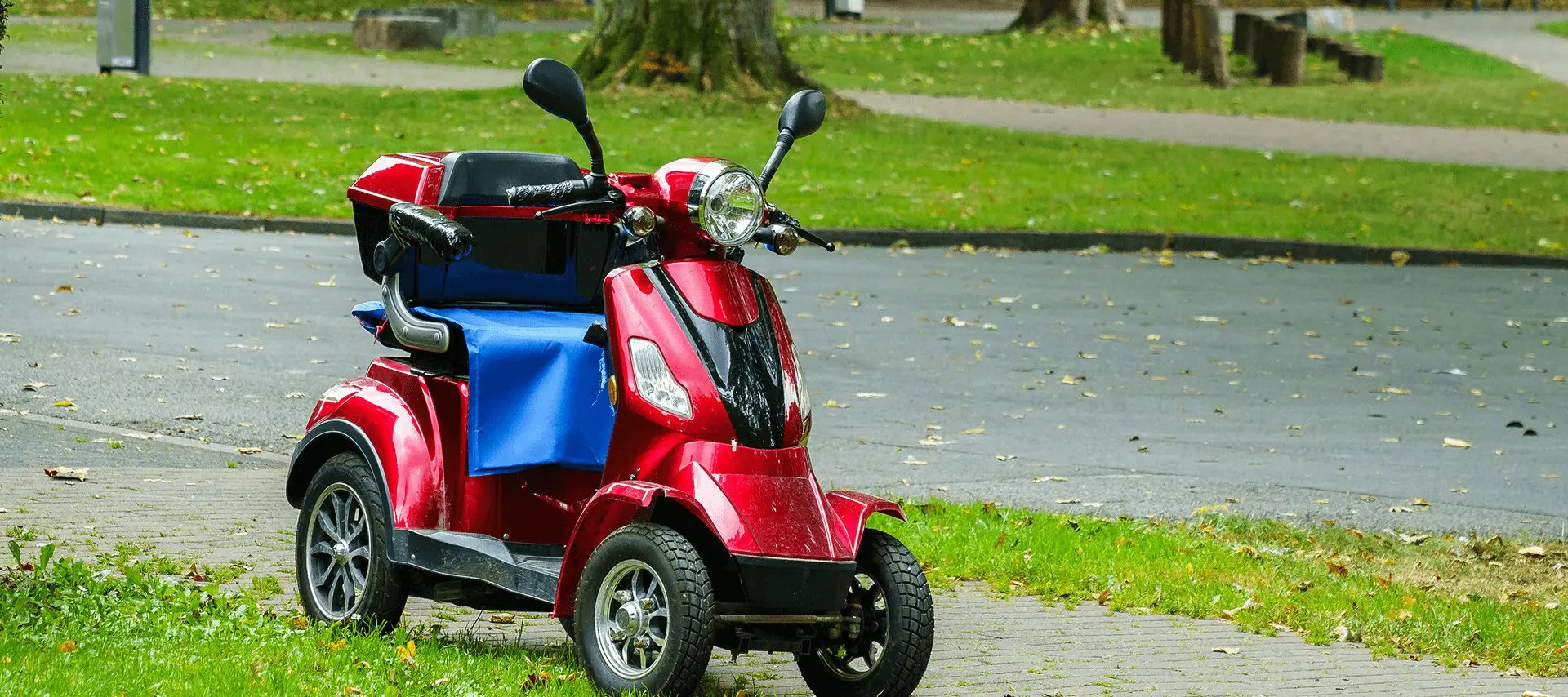 Red mobility scooter parked on a path.